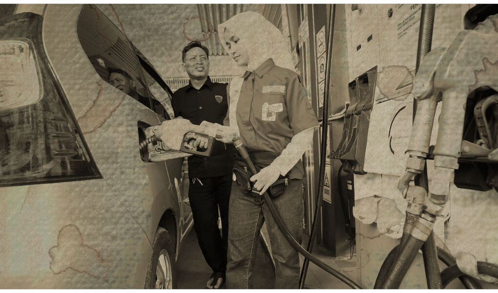 Worker refueling a car at a Jakarta gas station during rising fuel prices linked to Strait of Hormuz energy supply risks.
